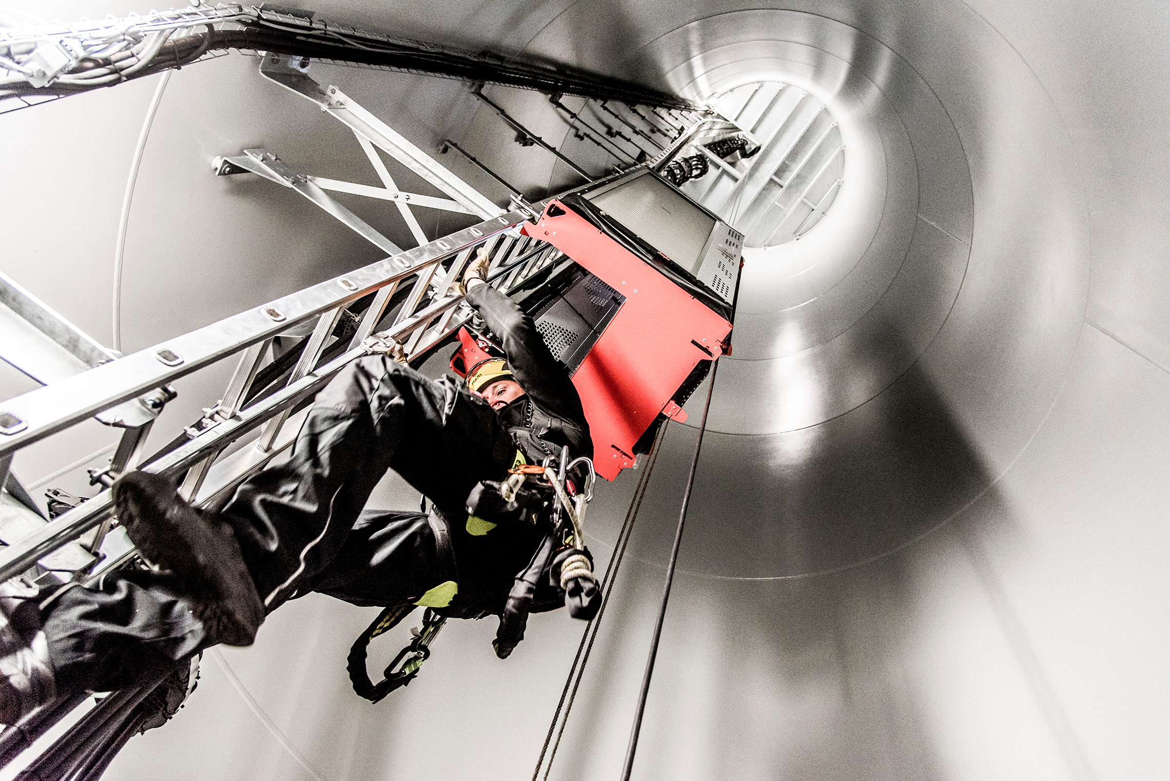 Mann steigt eine Leiter im Windkraftwerk hoch